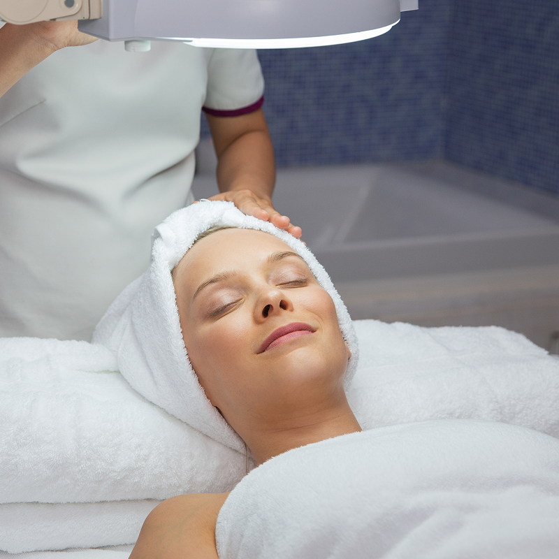 A patient lying down during an advanced dermatology signature treatment, showcasing medical-grade skin rejuvenation in a clinical setting.